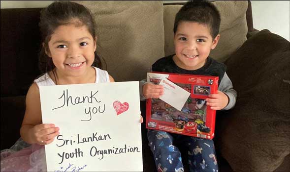 two happy kids holding a thank you sign